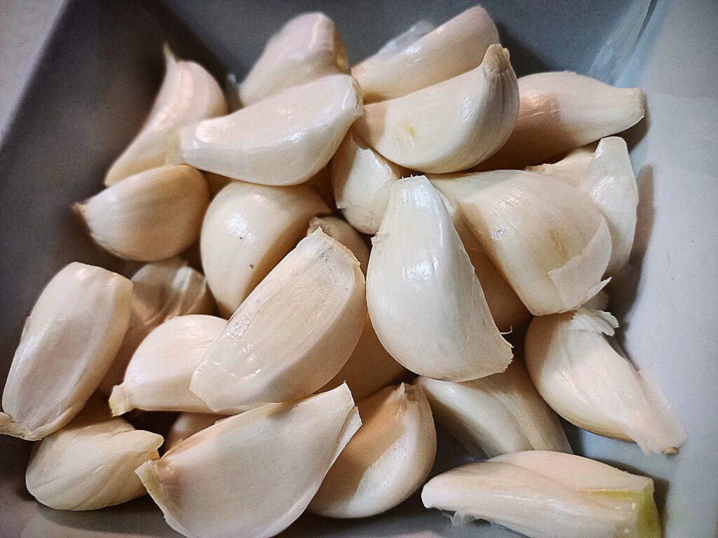 individual garlic cloves in a square bowl
