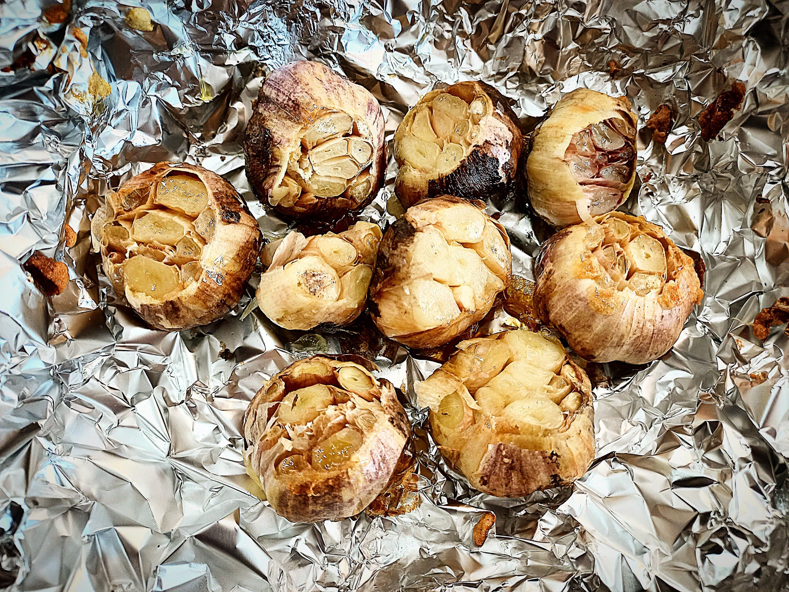 Roasted garlic heads on a piece of tin foil