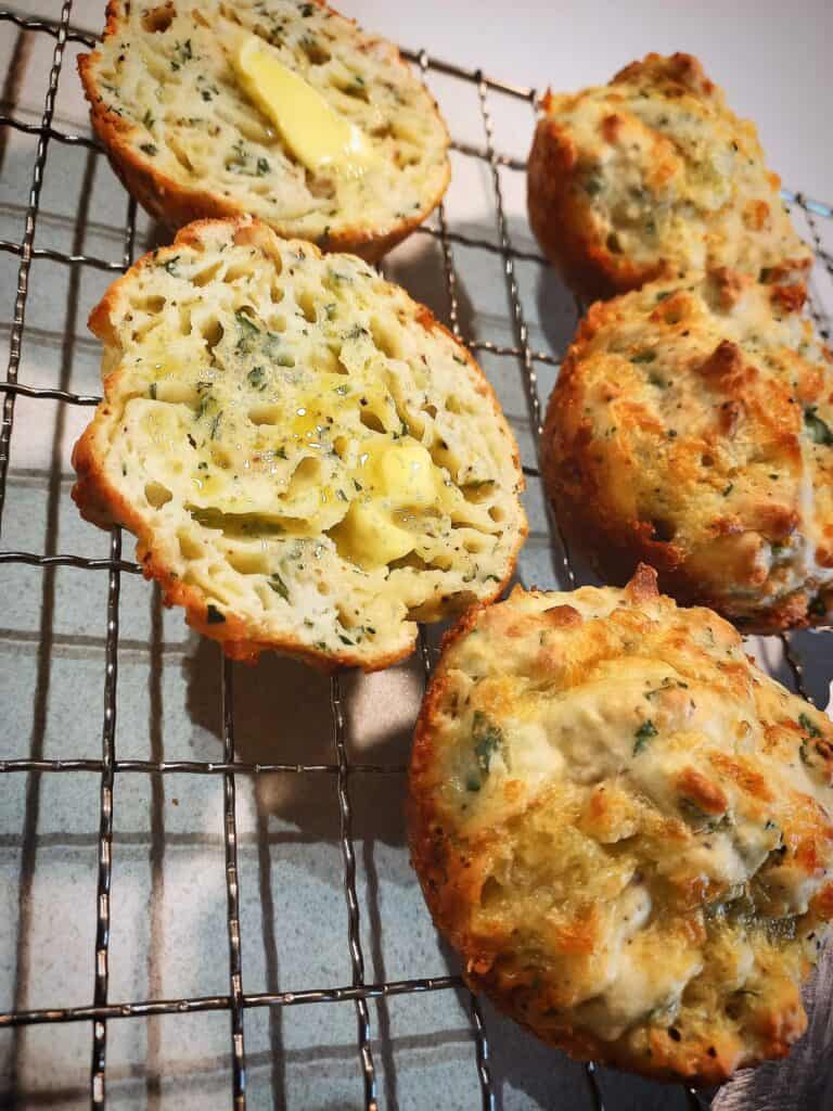 3 whole and 1 cheese and onion rolls cut in half on a wired rack