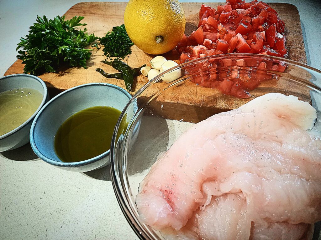 All the ingredients for Baked blue cod with lemon, parsley, tomatoes and white wine
