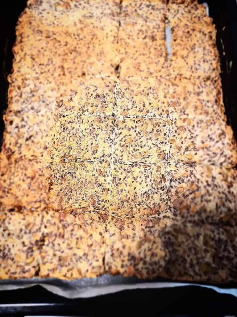 Freshly baked sunflower seeds crackers on a baking tray cut in to squares
