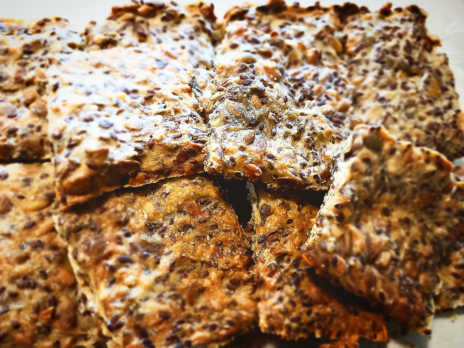11 Square pieces of Sunflower seed crisp bread piled up on a plate