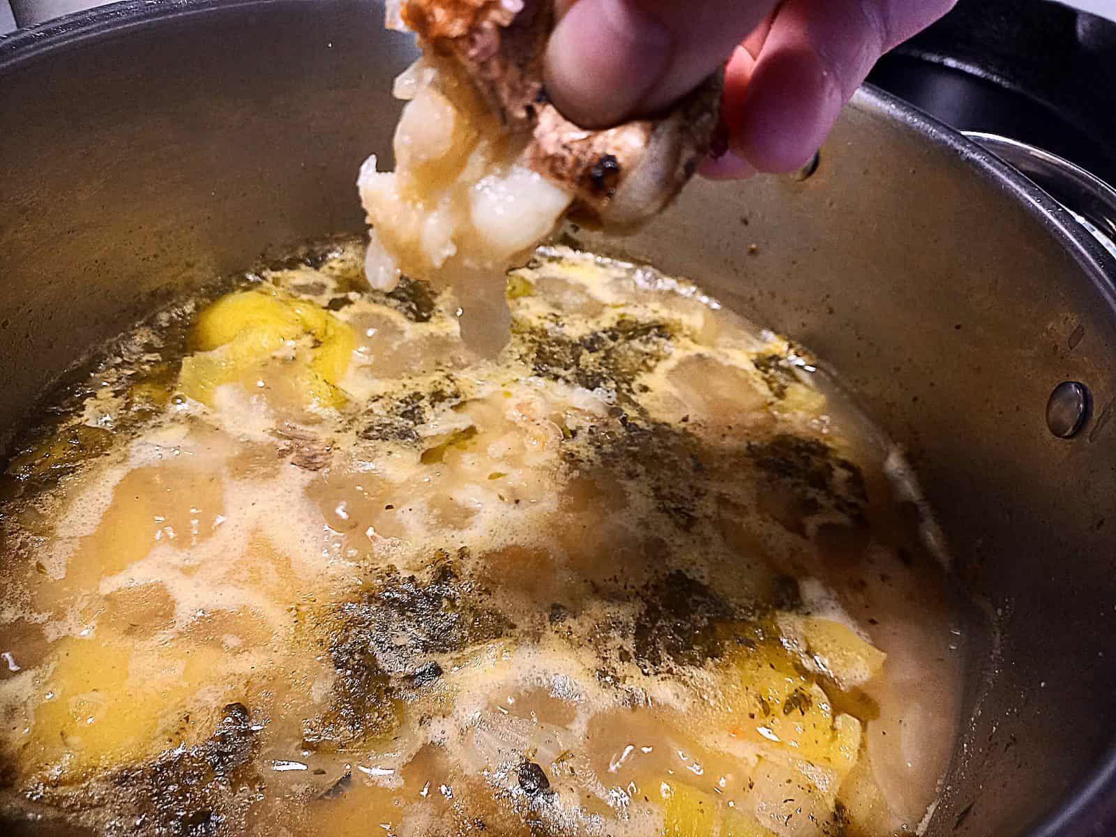 Squeezing roasted garlic in to the potato cream soup pot