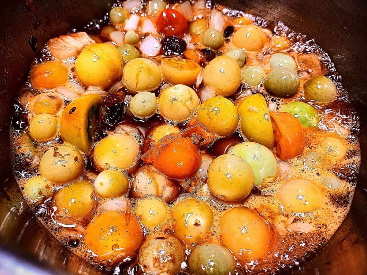 Green tomato and chili chutney ingredients in a sauce pan early on in the cooking process