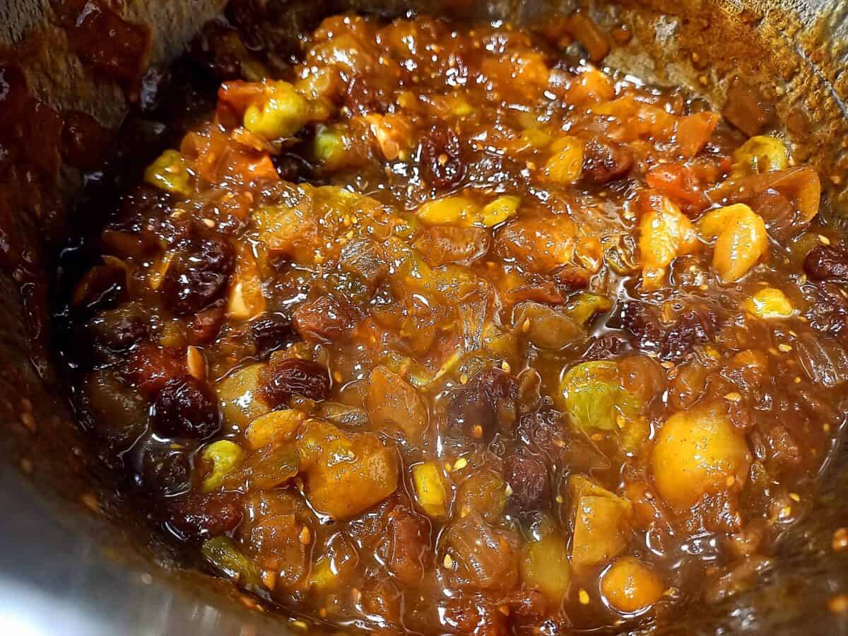 Green tomato and chili chutney cooking in a sauce pan to thick consistency