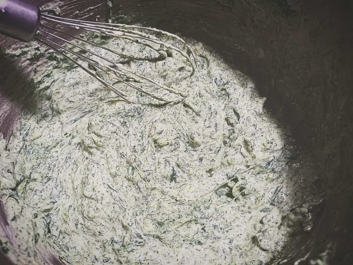 Making creamed nettles in a sauce pan using a balloon whisk