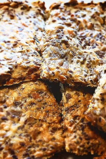 11 Square pieces of Sunflower seed crisp bread piled up on a plate