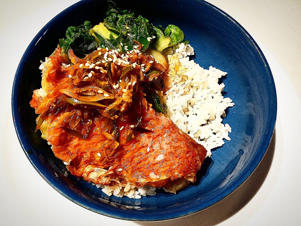 Pan fried scarlette wrasse with xo sauce, steamed rice and asian greens in a blue bowl plate