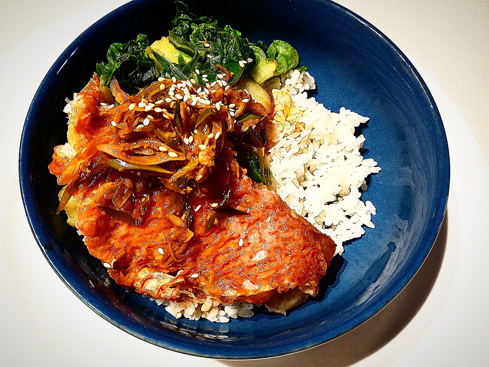 Pan fried scarlette wrasse with xo sauce, steamed rice and asian greens in a blue bowl plate