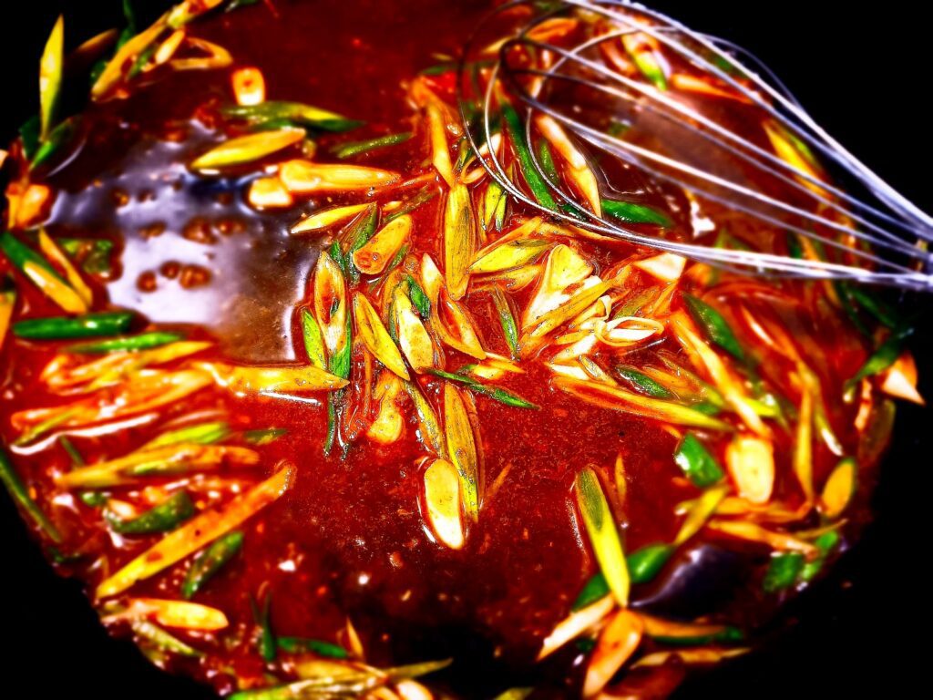 Making spring onion and xo sauce in a frying pan with a whisk