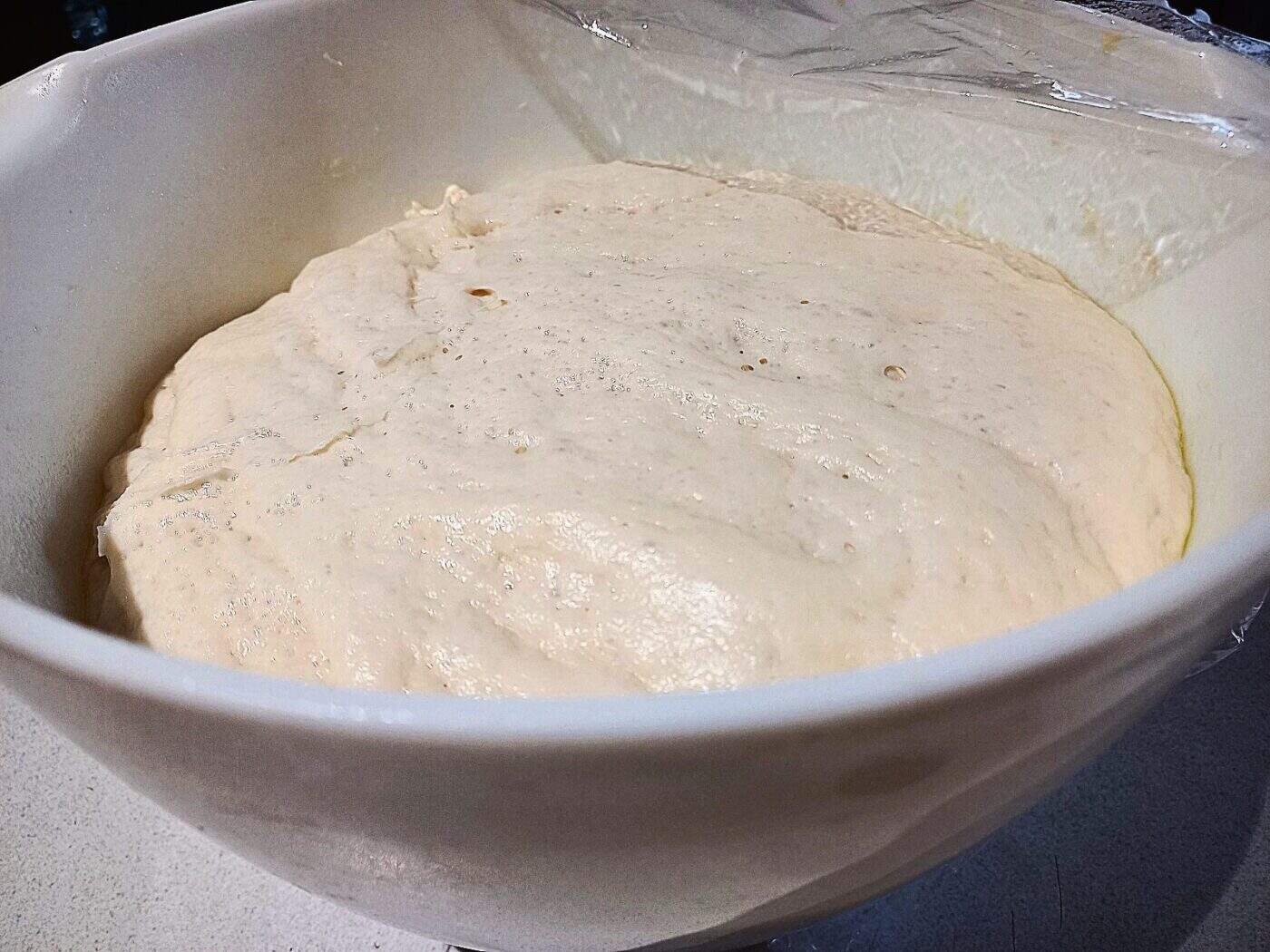 pizza dough after proofing in a with bowl