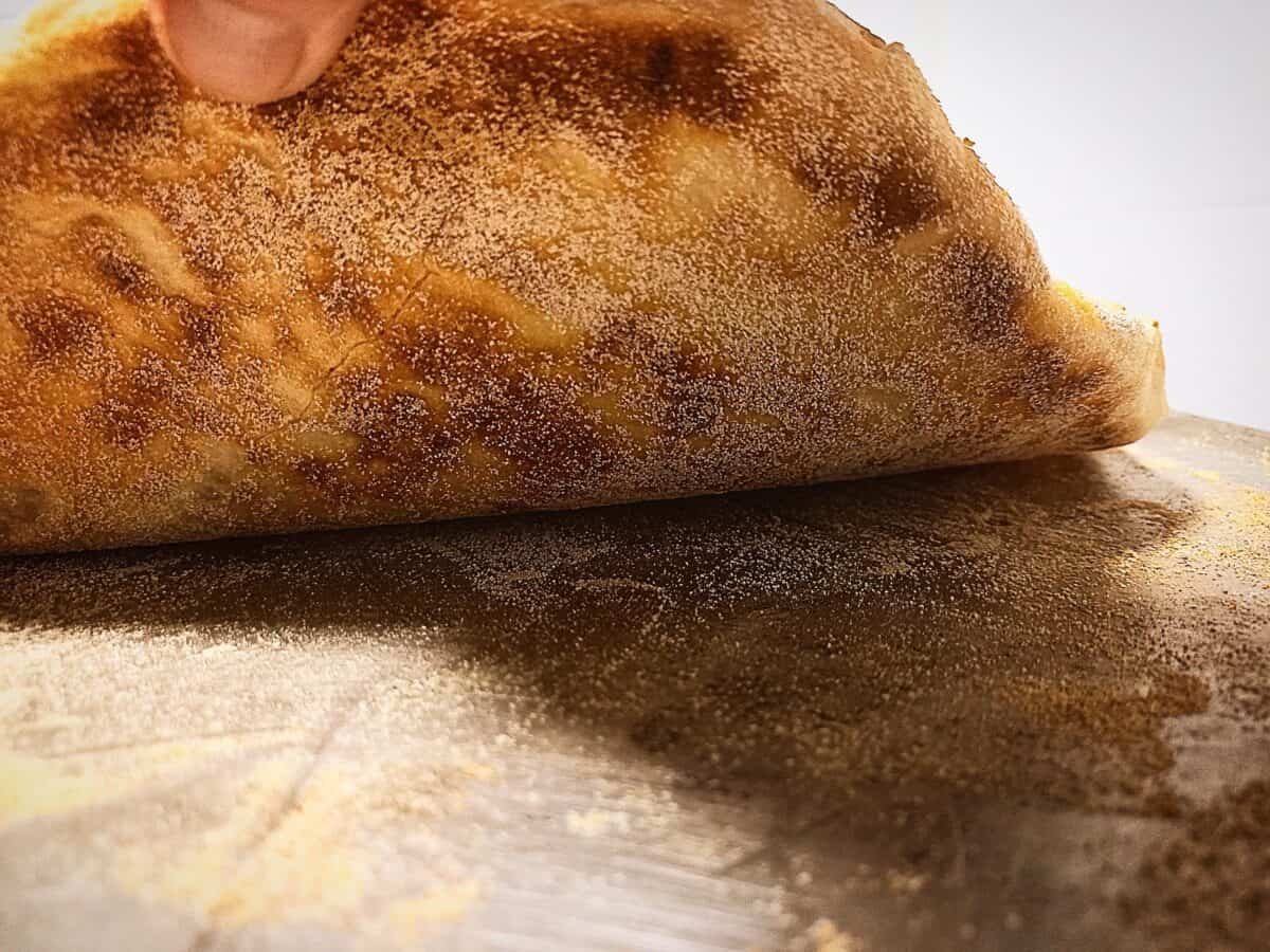 Lifting the corner of the pizza base. Golden brown underneath