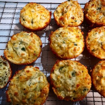 10 cheese and onion rolls on a wired rack
