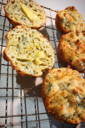 3 whole and 1 cheese and onion rolls cut in half on a wired rack