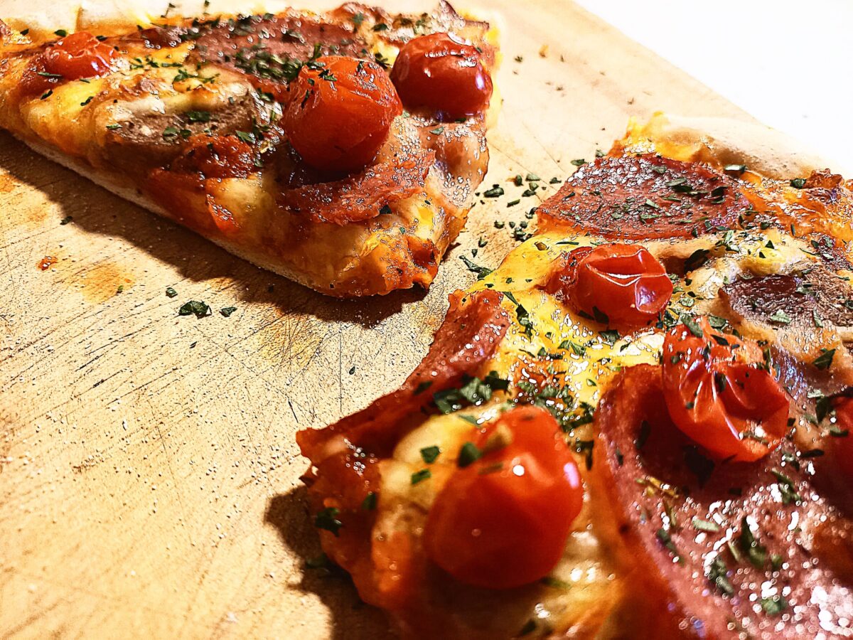 2 pizza slices on a wooden chopping board