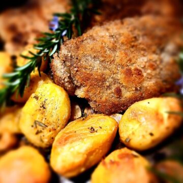 venison schnitzel with roasted potatoes and rosemary sprigs