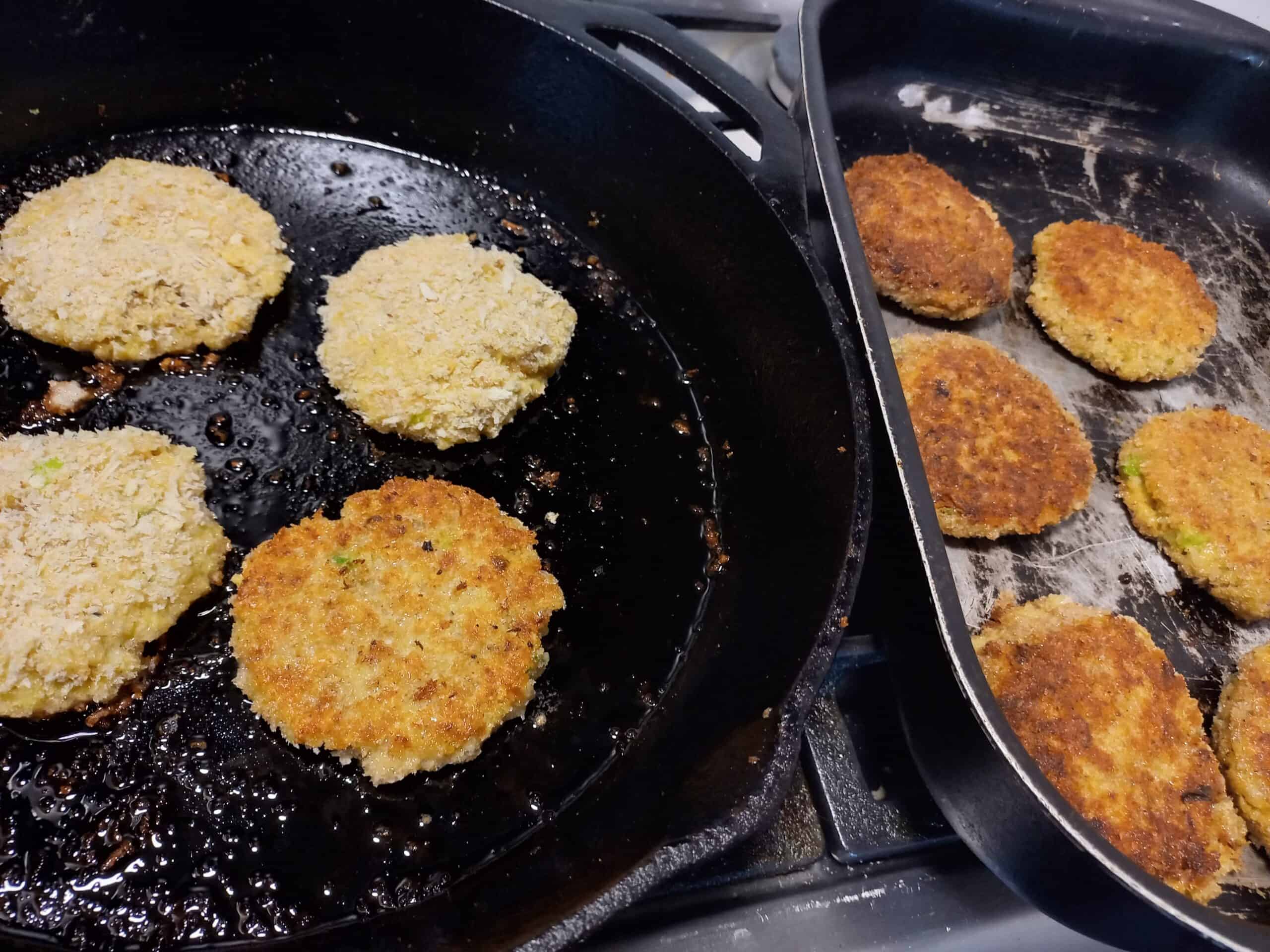 clam fritters frying in a skillet frying pan