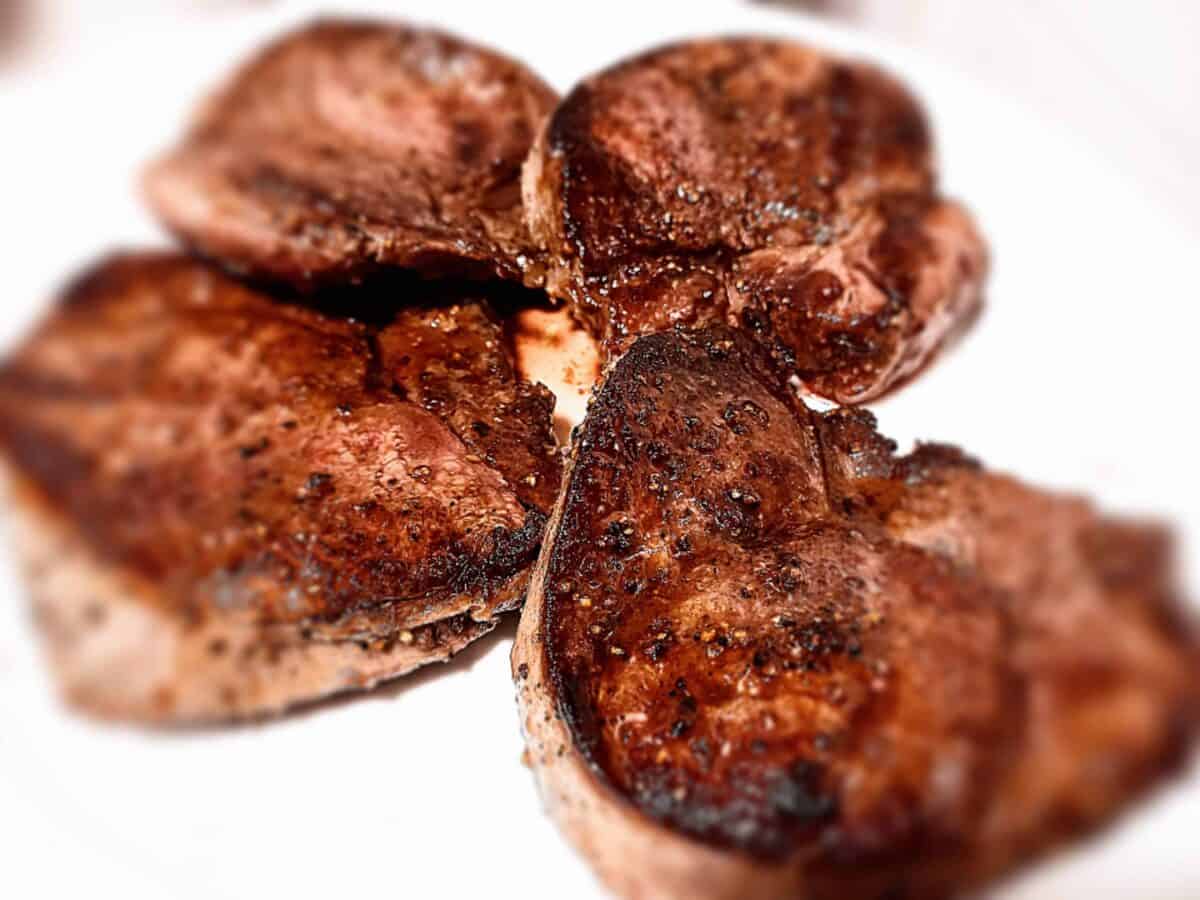 Venison steaks resting on a white plate