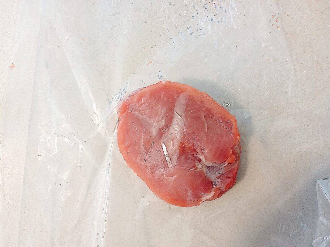 wild pork meat inside a plastic bag on a white kitchen bench