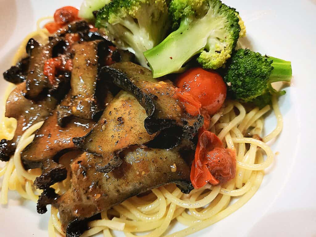 Paua sauteed with cherry tomatoes and steamed broccoli served on top of spaghetthi