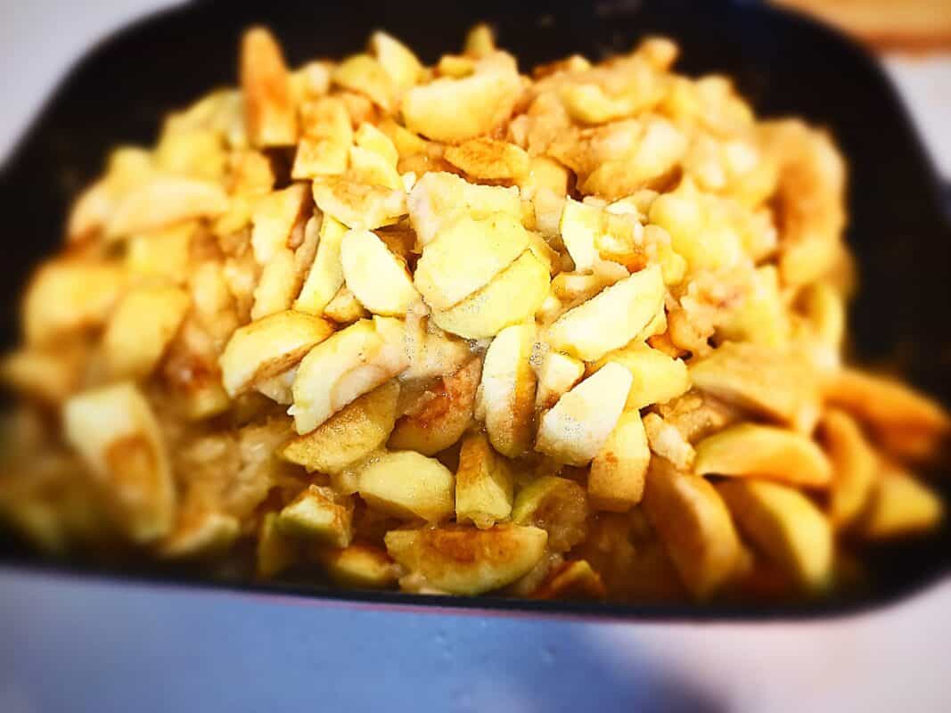 Apple slices in a large square sauce pan ready to cook for apple sauce compote