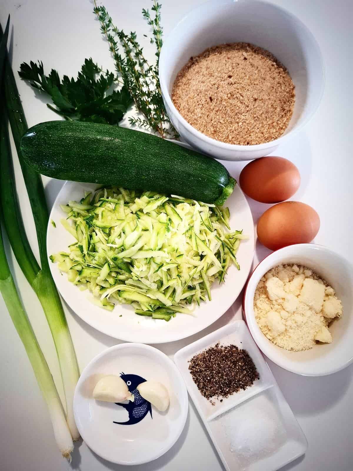 Ingredients for zucchini garlic bites on a white table