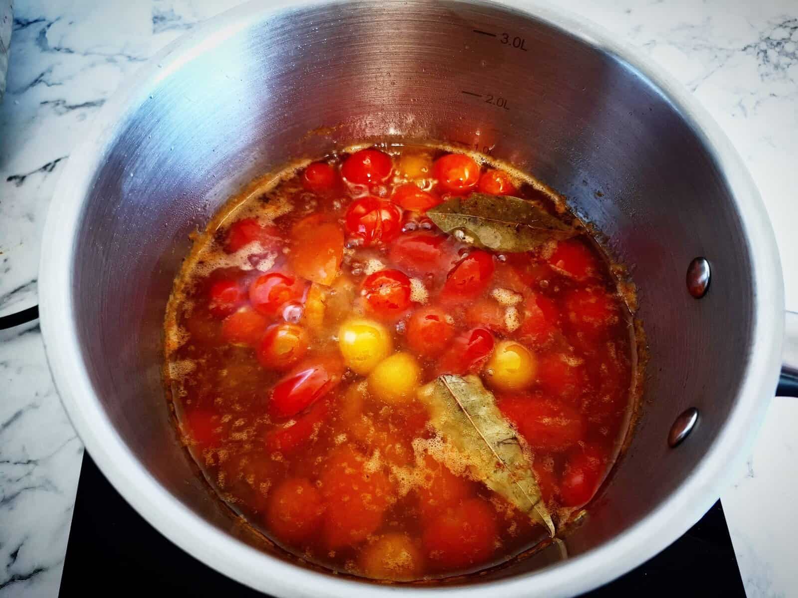 tomatoes, oil, garlic, thyme, bayleaves, salt and pepper slowly simmering in a saucepan