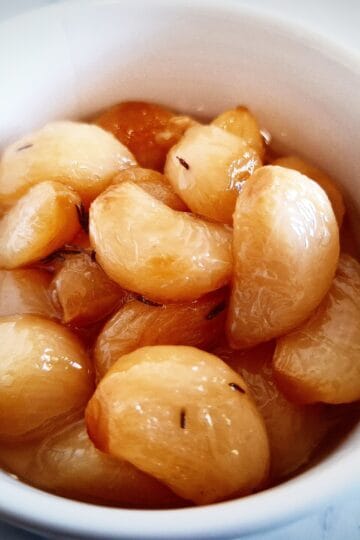 confit garlic cloves in a white ramekin