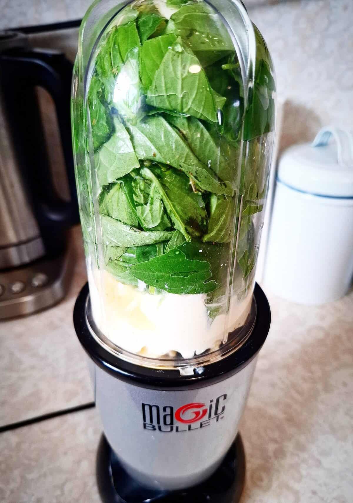 Basil dip ingredients in a nutri bullet ready to be blended