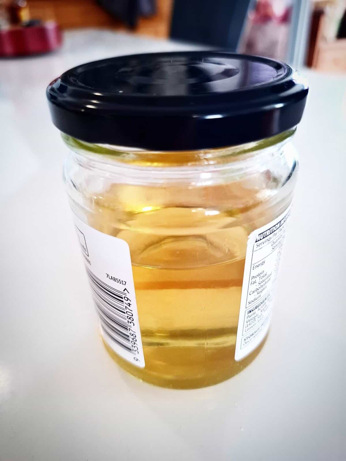 Sushi vinegar in a recycled glass jar on a white table