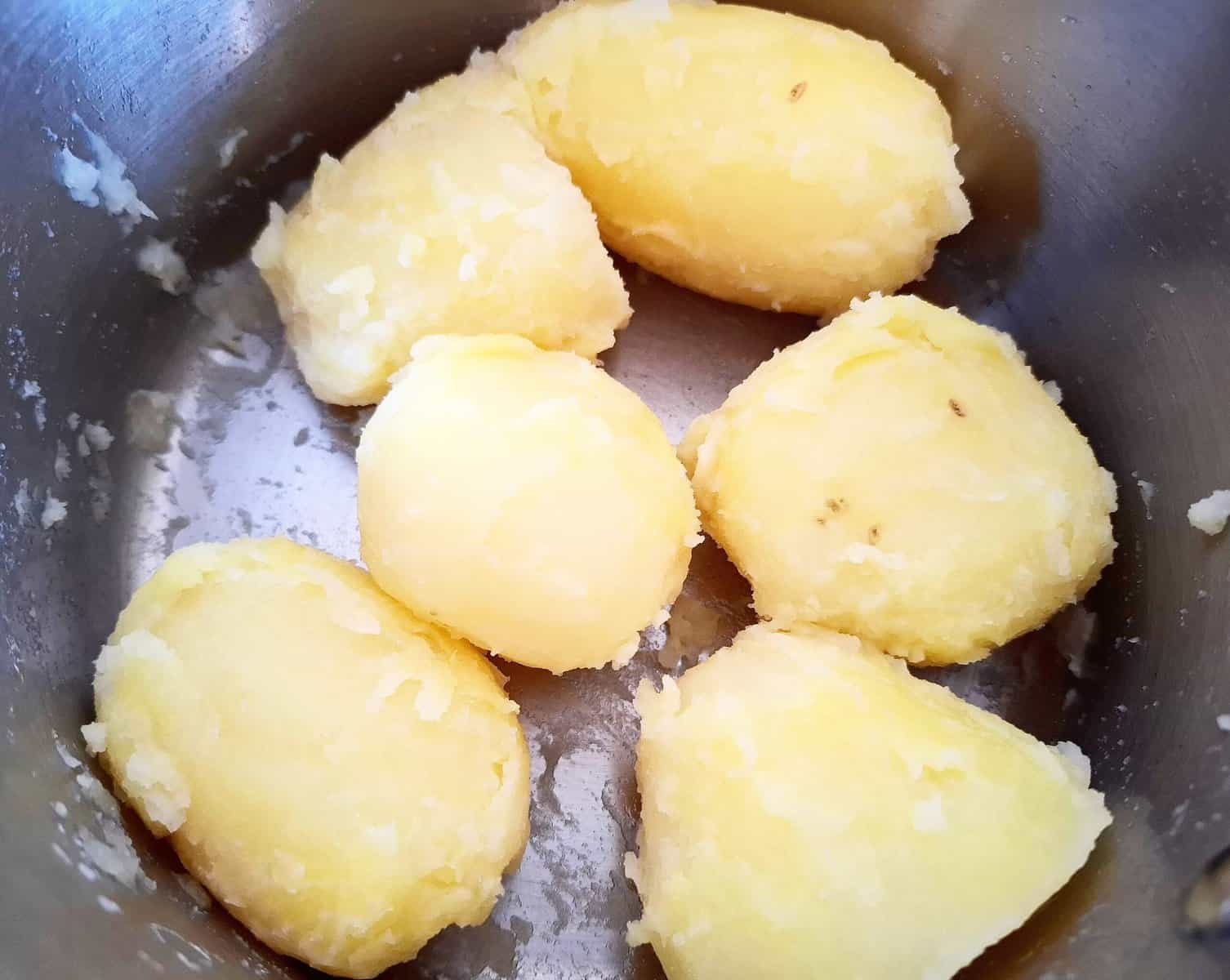 Cooked potatoes that has been shaken around in a saucepan to roughen the surface of the potatoes for a crispy texture