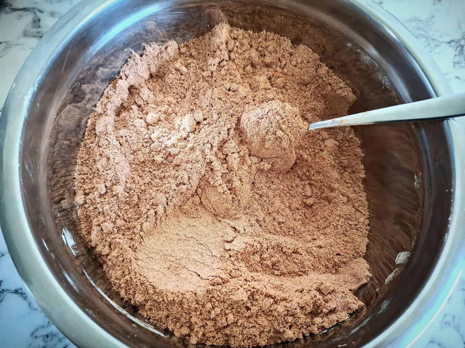 Mixing the spice coating spices in a stainless steel bowl with a spoon