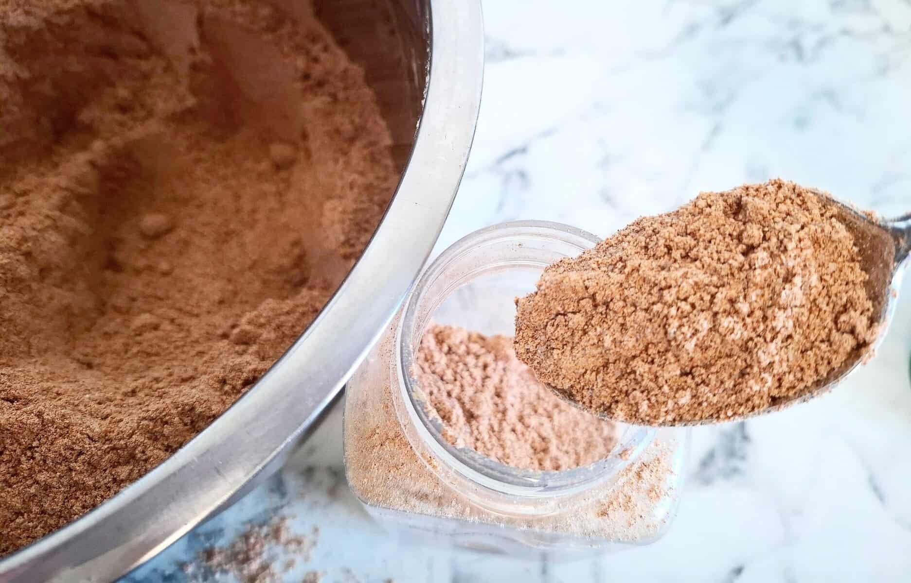 Transferring the spice coating mixture from a large mixing bowl to a spice shaker