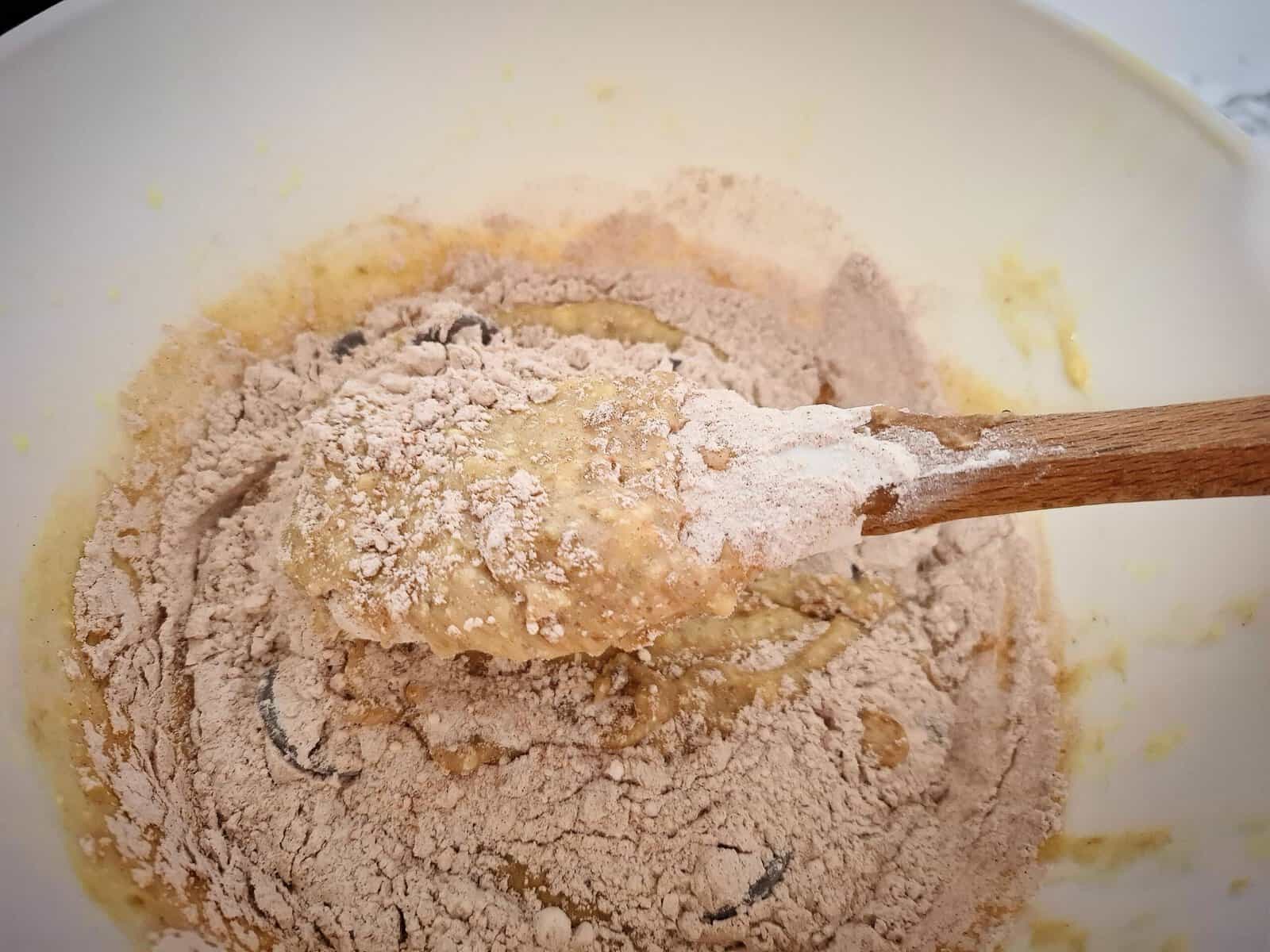 Dried ingredients are being folded through the banana, butter and egg mixture.