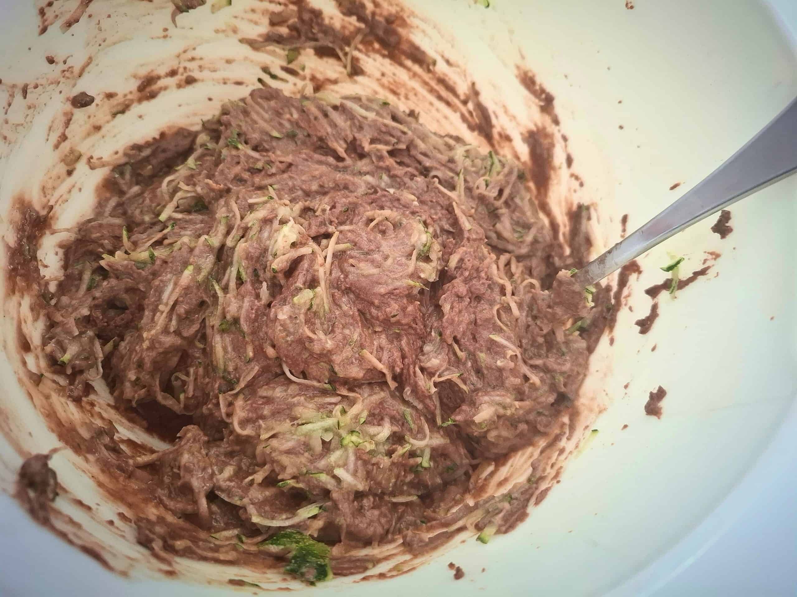 Grated courgette is being added to the cake mix.
