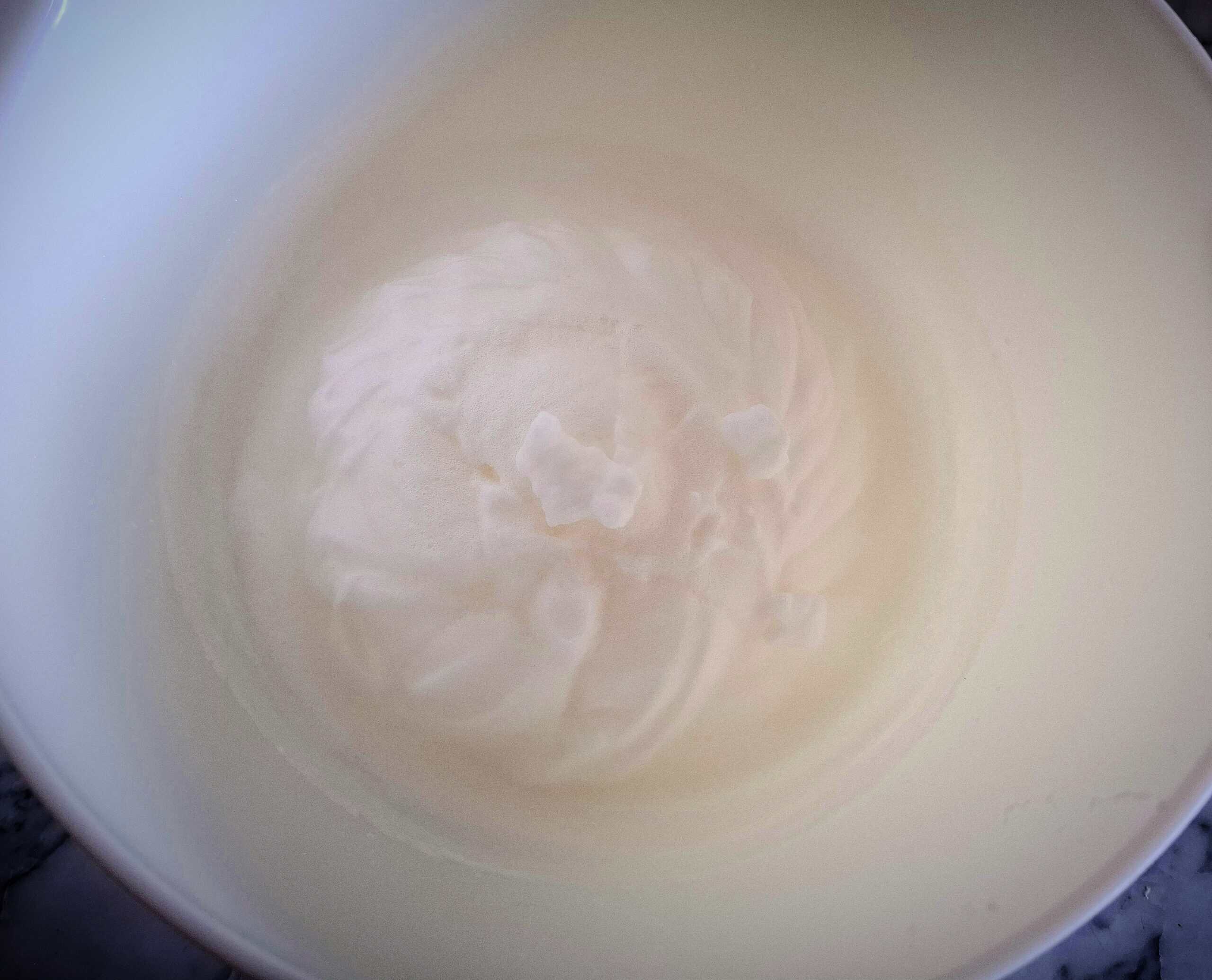 Whipped egg whites in a white bowl.
